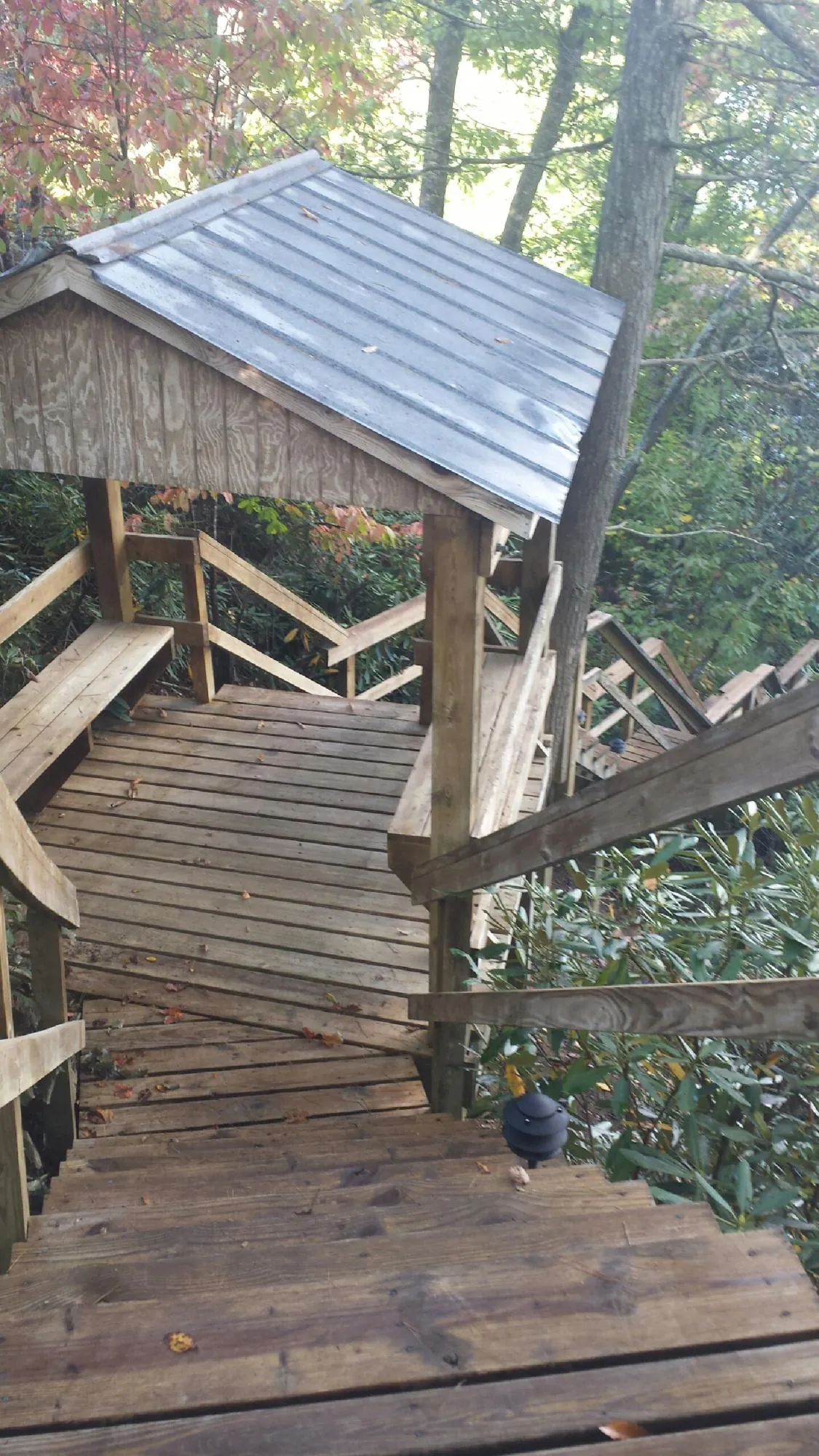Metal roofed shelter over wooden steps on a wooded walkway — Skylight Repair & Installation work by our crew in Shade Gap